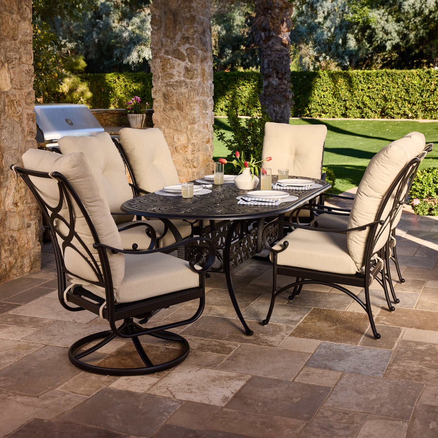 Patio set with a round table and four chairs on a stone patio., image 3